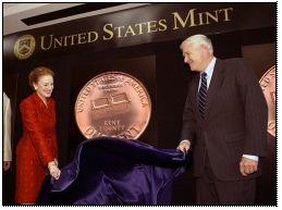 Fore and an assistant unveil the Kent County penny, which boasts a nod to the cinder-block factory.